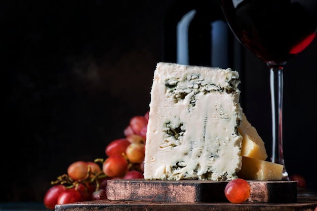 Bodegón de vino de Oporto y queso azul en estilo rústico mesa de madera vintage fondo enfoque selectivo