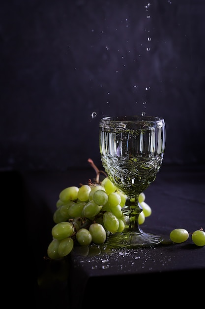 Bodegón con vino, uvas y copa de estilo antiguo.