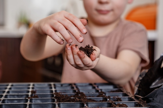 Foto boden in händen. kinderhand, die den boden hält. nahansicht.