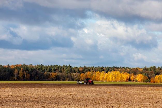 Bodenbearbeitung mit einem roten Traktor mit Pflügen auf einem landwirtschaftlichen Feld