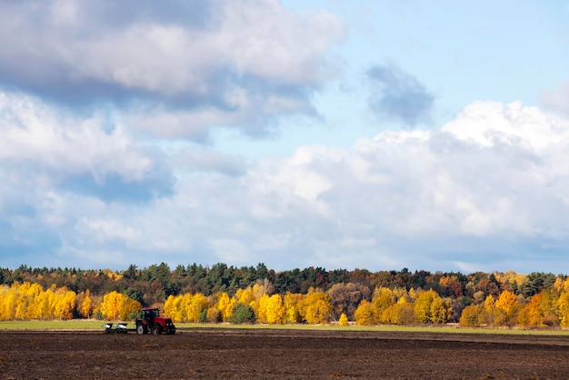 Bodenbearbeitung mit einem roten Traktor mit Pflügen auf einem landwirtschaftlichen Feld