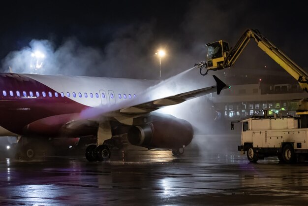 Foto bodenentfrorung eines passagierflugzeugs auf dem nachtflugplatz