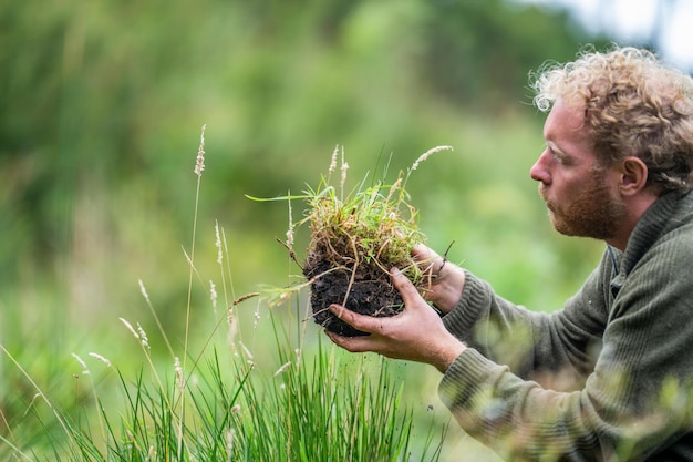 Bodenwissenschaftsstudent Landwirtschaft beobachtet eine Bodenprobe Mädchen auf einer Farm beobachtet Pflanzenwurzeln