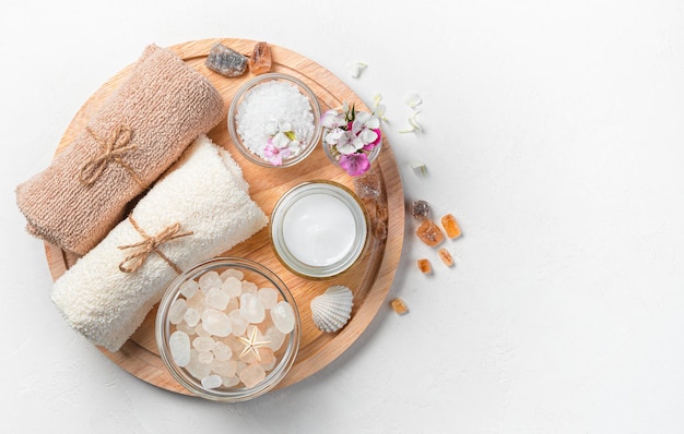 Body Care Kit Spa-Set für die folgenden Blütenblätter auf einem Holzbrett auf hellem Hintergrund