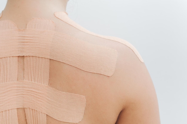 Body feminino com kinesio tape nas costas e ombros. Conceito de gravação de cinesiologia