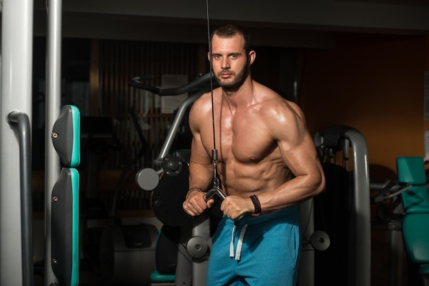 Bodybuilder, der schwere Übungen für Trizeps im Fitnessstudio macht