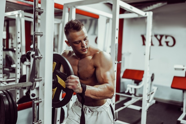 Bodybuilder, der sich auf Schwergewichtsübungen mit Langhantel im Fitnessstudio vorbereitet