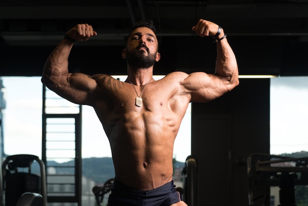 Bodybuilder Fitness Model posiert nach Übungen mit doppeltem Bizeps