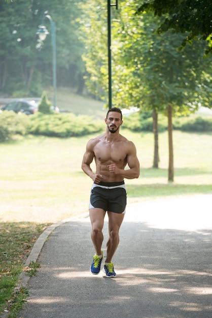 Bodybuilder-Läufer, der während des Trainings im Freien im Park joggt