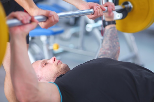 Bodybuilder mit Langhantel im Fitnessstudio Bodybuilder