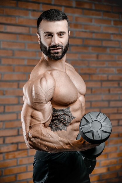 Bodybuilder starker Mann, der Bizepsmuskeln aufpumpt