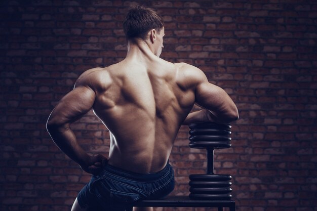 Bodybuilder starker Mann, der Rückenmuskeln aufpumpt