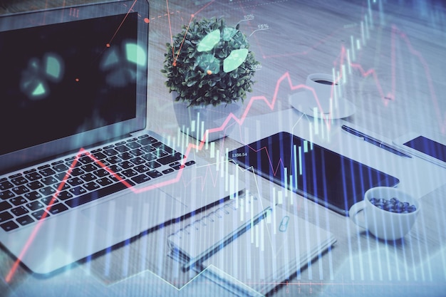 Börsendiagramm auf Hintergrund mit Schreibtisch und PC Multi-Exposure-Konzept der Finanzanalyse