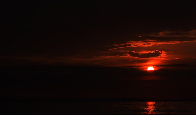 Bösartiger roter Himmel von Sonnenaufgang bis Sonnenuntergang auf See