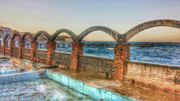 Foto bogen an einer stützmauer am meer gegen den himmel