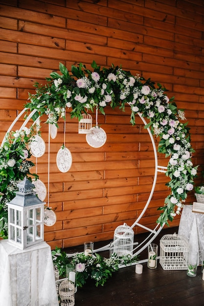 Bogen für Hochzeitszeremonie a ist dekoriert mit weißen Blumen und Grünpflanzen Photowall Raum oder platzieren Sie Kerzen auf dem Hintergrund der Holzwand Hochzeitsdekoration auf Boho-Stil Traumfänger