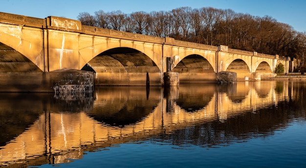 Foto bogenbrücke über den fluss vor klarem himmel