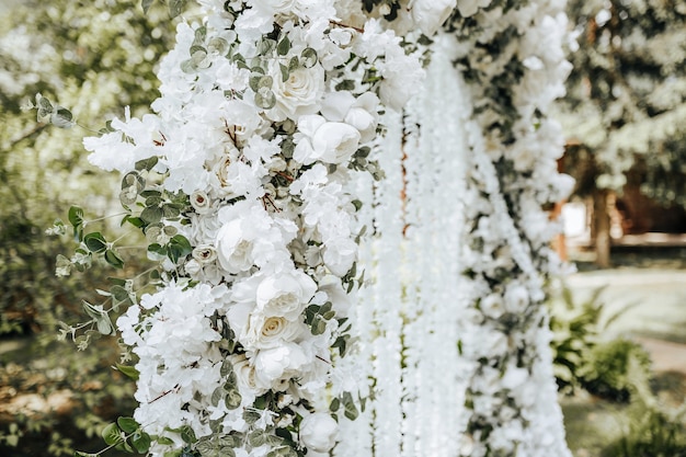 Bogendekor mit weißen Blumen für eine Hochzeitszeremonie in der Natur