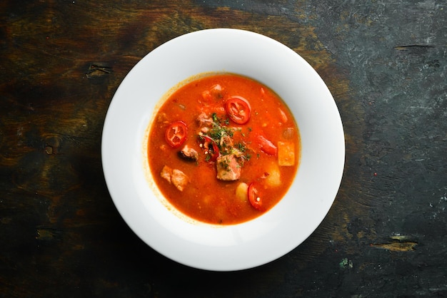 Bogracher Suppe Ungarische Küche Suppe mit Fleischgemüse und Chilischoten In einer weißen Platte Draufsicht