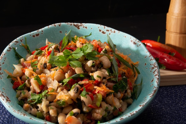 Bohnensalat ein hausgemachter Salat mit Bohnen Tomaten Zwiebeln Paprika und Kräuter closeup auf einem Teller