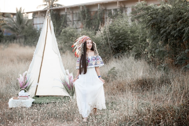 Boho boêmia estilizada usando um maxi vestido indiano e joias no campo de outono