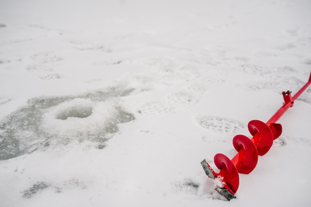 Bohren Sie ein Loch mit einer Schraube Die Fischer- und Bohrschnecke Power Auger Winterangeln auf dem zugefrorenen Eissee