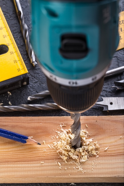 Bohrendes Holz des Tischlers unter Verwendung der tragbaren Bohrmaschine