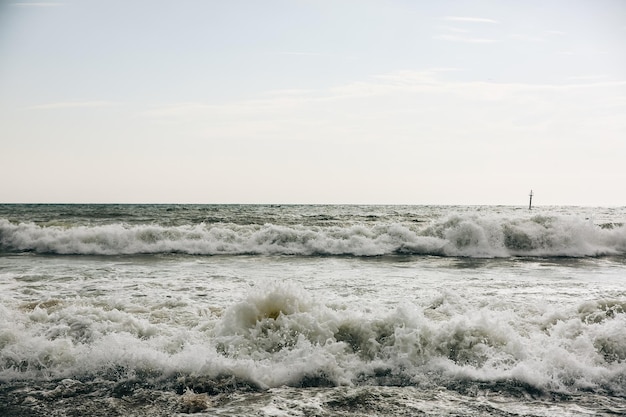 Bóia nas ondas do mar com espuma Praia vazia Viagem de férias de verão Oceano tempestuoso