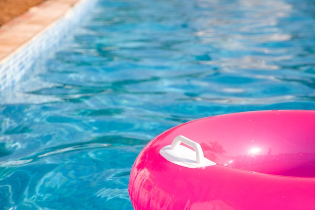 Boia rosa sobre a piscina no verão