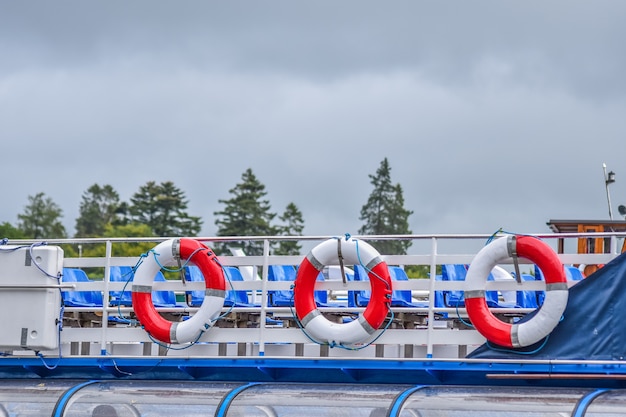 Boia salva-vidas vermelhas e brancas no barco com fundo nebuloso após chover,