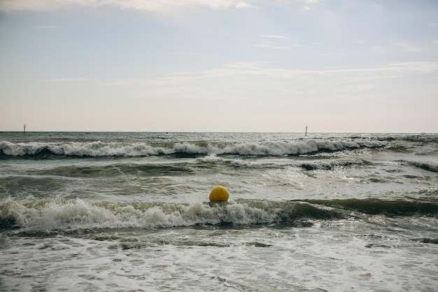 Boje in den Meereswellen mit Schaum Leerer Strand Sommerferien reisen Stürmischer Ozean