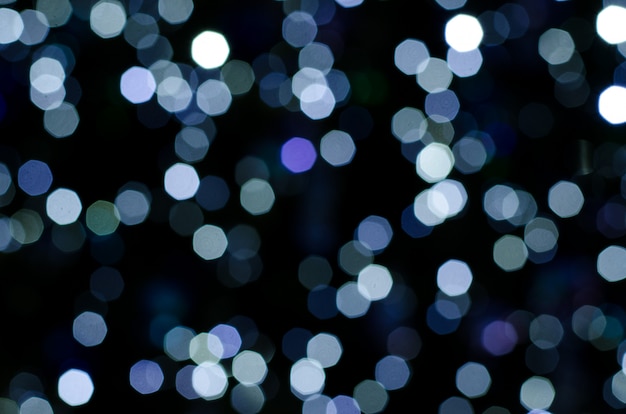 Bokeh abstracto de las luces del adorno en fondo oscuro.