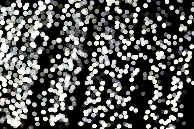 Bokeh abstrato das luzes brancas da cidade em fundo preto. desfocado e turva muitas luzes redondas