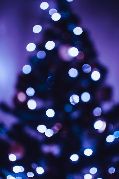 Bokeh azul de uma guirlanda de led em uma árvore de natal. conceito de bokeh e luz festivos. copie o espaço.