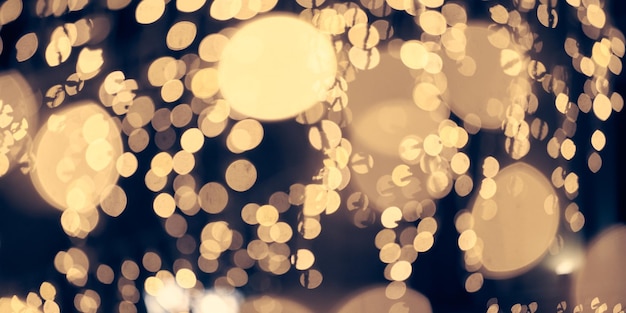 Bokeh de luzes amarelas pálidas de guirlandas de férias de natal turva luzes de fundo abstratas festivas