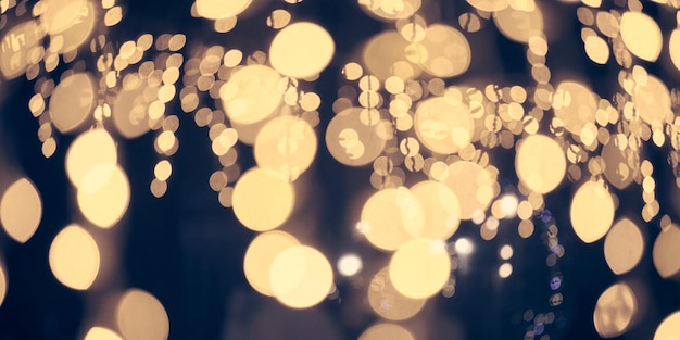 Bokeh de luzes amarelas pálidas de guirlandas de férias de natal turva luzes de fundo abstratas festivas