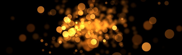 Foto bokeh dorado resplandor sobre fondo negro.