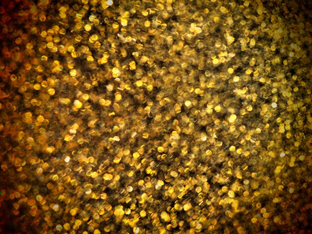 Bokeh-Licht aus Gold glitzert. Goldener Glitzer Textur Hintergrund. Funkelndes Glitzer-Geschenkpapier mit Pailletten und Funkeln. Festliches goldenes Bokeh und Glitzern. Schöner Makrohintergrund.