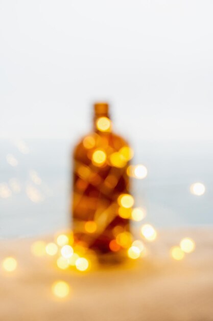 Foto bokeh con luces amarillas y silueta de botella