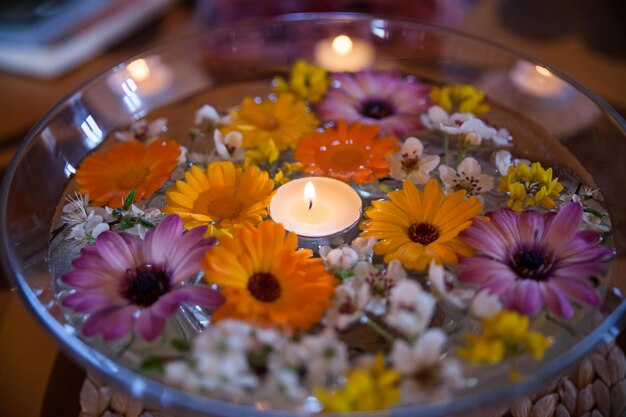 Bol de vidro de spa com flores e vela flutuante