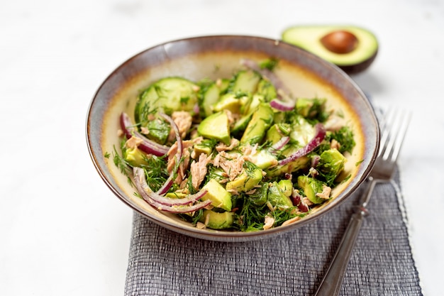 Foto un bol con ensalada de atún y aguacate.