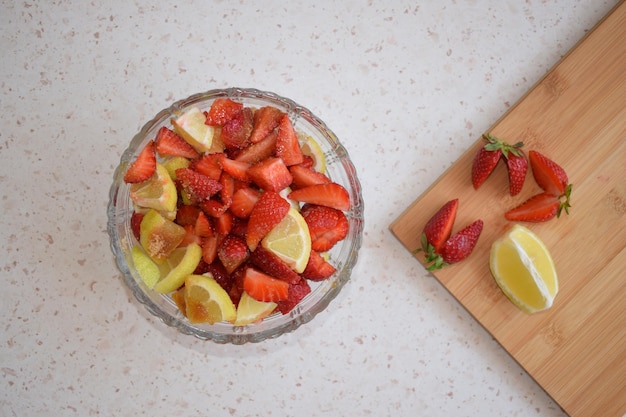 Un bol de fresas un limón y azúcar moreno Los ingredientes de una limonada