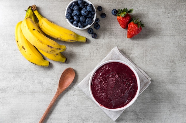 Bol de helado brasileño congelado y de acai berry. con frutas sobre fondo de madera. Vista superior del menú de verano. de cerca.