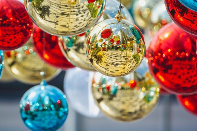 Bola de adornos de cristal de Navidad brillante colgando de abeto sobre bokeh colorido con festivo
