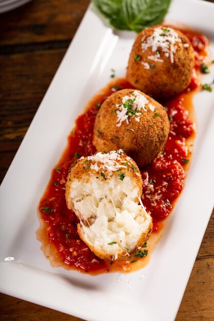 Bola de arroz italiana rellena de arancini cubierta con migas de pan