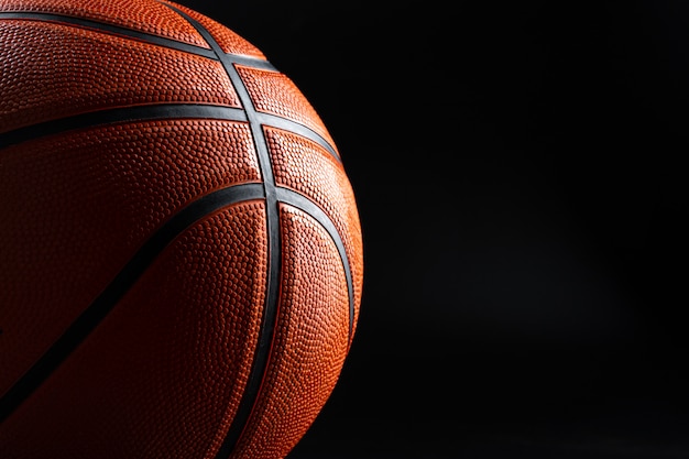Bola de baloncesto de cerca en una superficie oscura