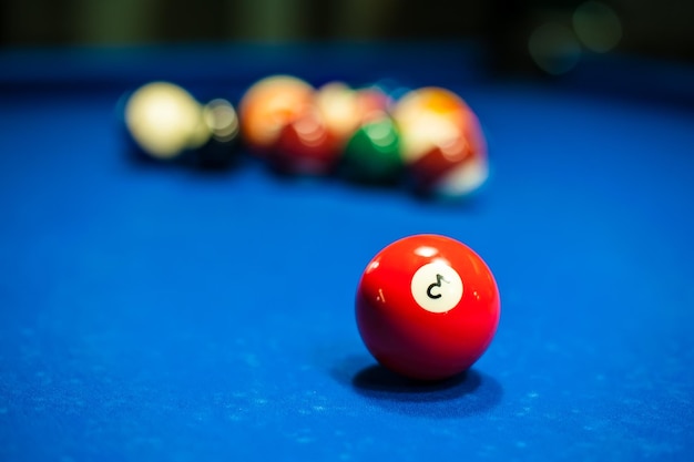 Foto una bola de billar roja está sobre una mesa con un fondo de bolas borrosas