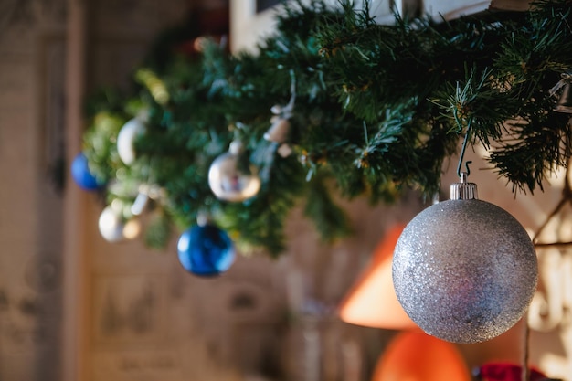 Bola de cristal y adornos en el árbol de Navidad Guirnalda de árbol de Navidad con bolas azules y plateadas closeup Desenfoque de perspectiva