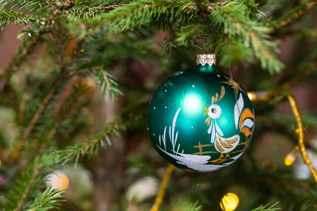 Foto bola de cristal con imagen de gallo en el árbol de navidad