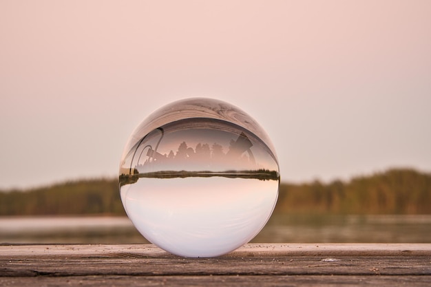 Foto bola de cristal en un muelle de madera en un lago sueco a la hora de la tarde naturaleza escandinavia